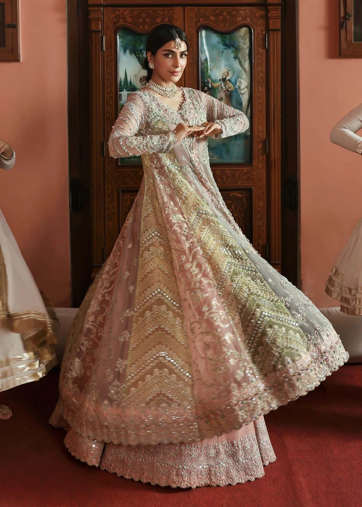Stunning jewel-toned lehenga suit with hand-embellished shirt, embroidered borders, and organza dupatta for a regal festive look.
