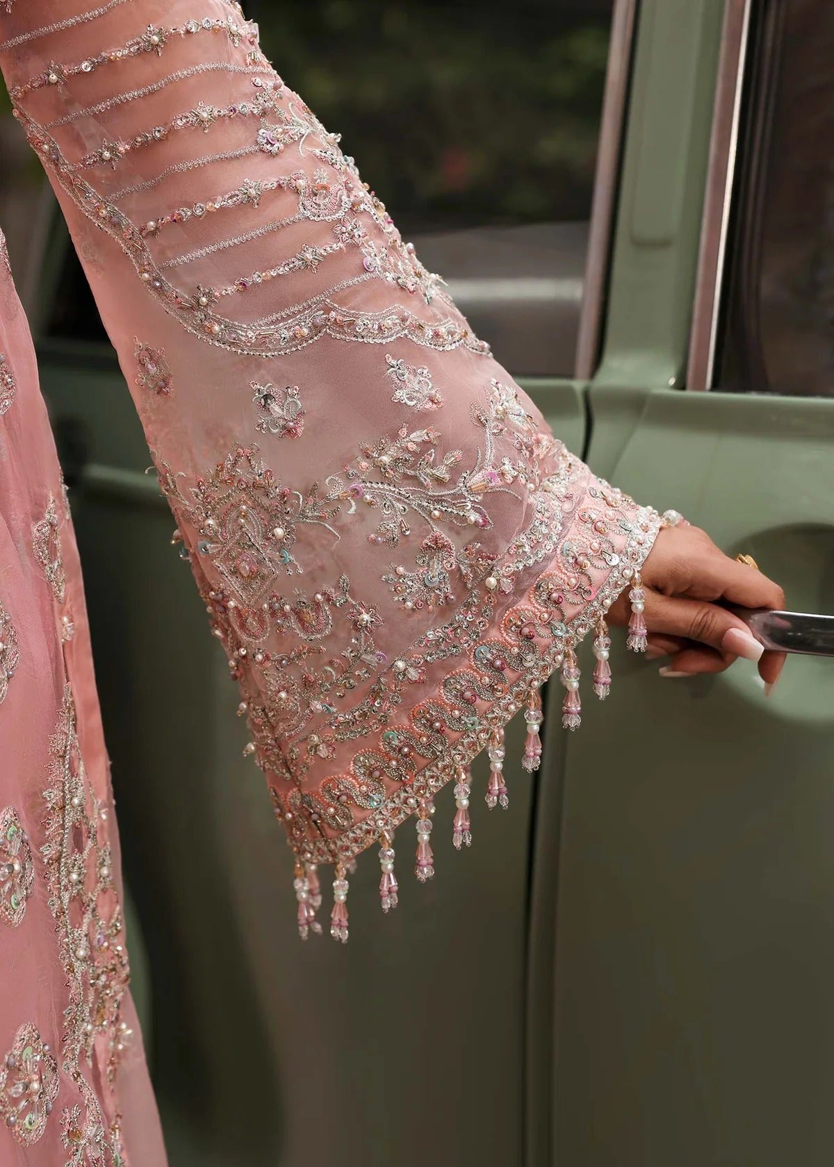 Ethereal blush rose suit with hand-embellished organza panels, ornate borders, and embroidered dupatta. A timeless choice for festive elegance.