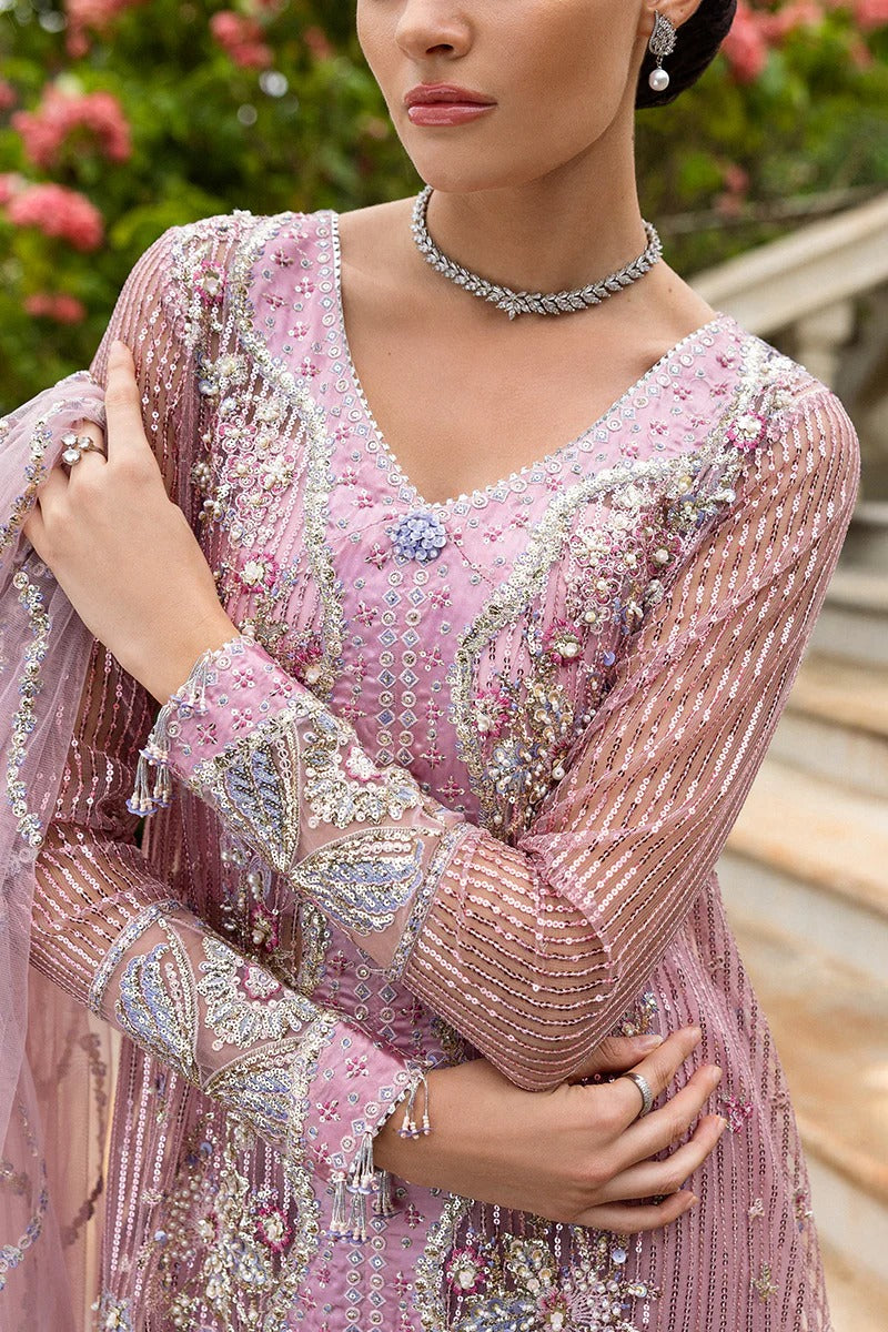 Stylish light pink dress with embroidered net shirt, sequined dupatta, embellished trouser, silk neckline, and handmade tassels for an elegant look.