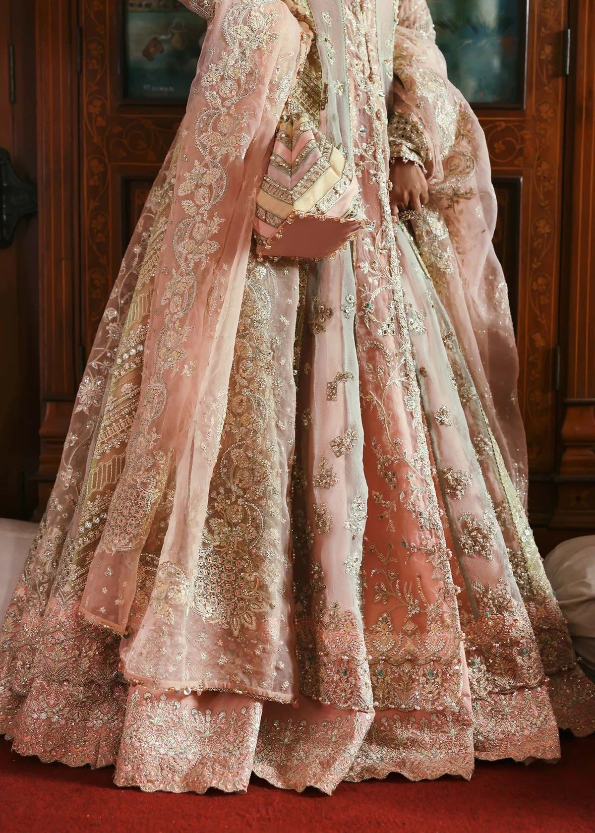Stunning jewel-toned lehenga suit with hand-embellished shirt, embroidered borders, and organza dupatta for a regal festive look.