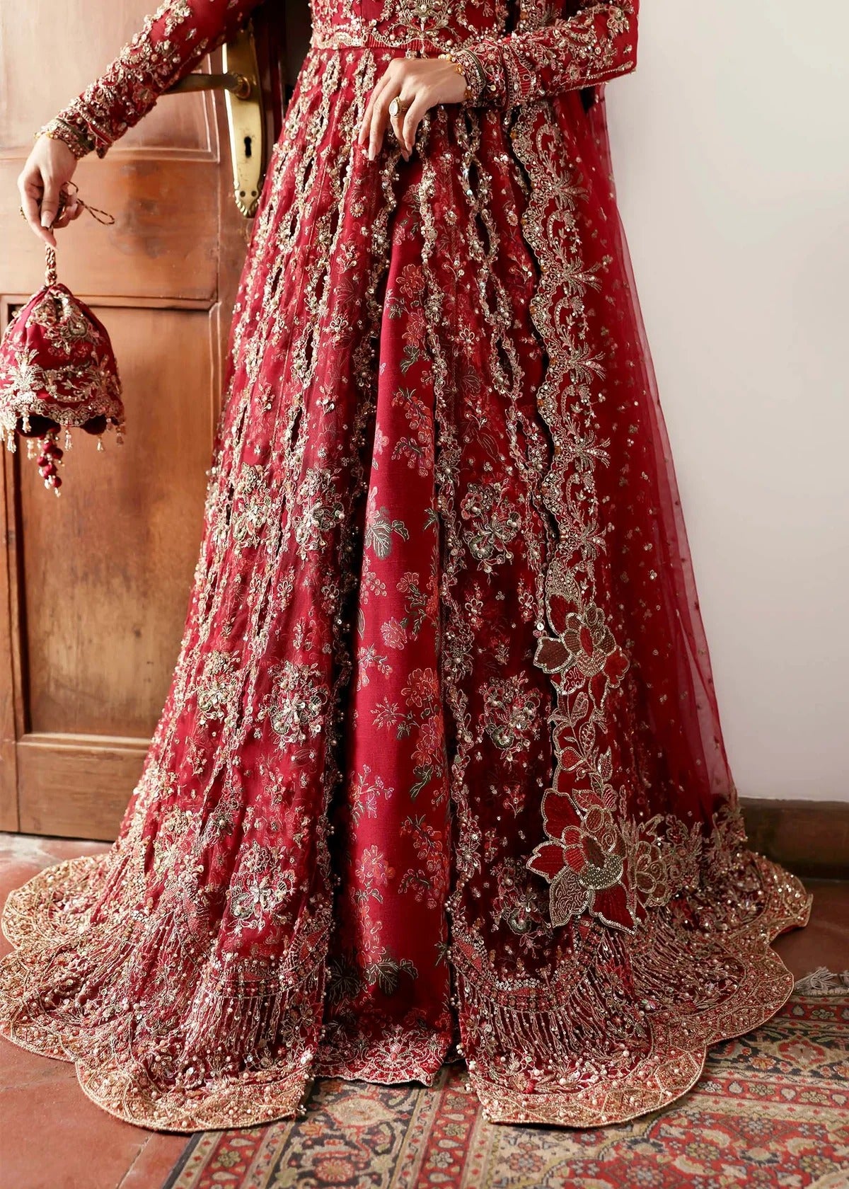 Regal crimson lehenga with hand-embellished panels, ornate borders, embroidered dupatta, and net body—perfect for festive and wedding elegance.