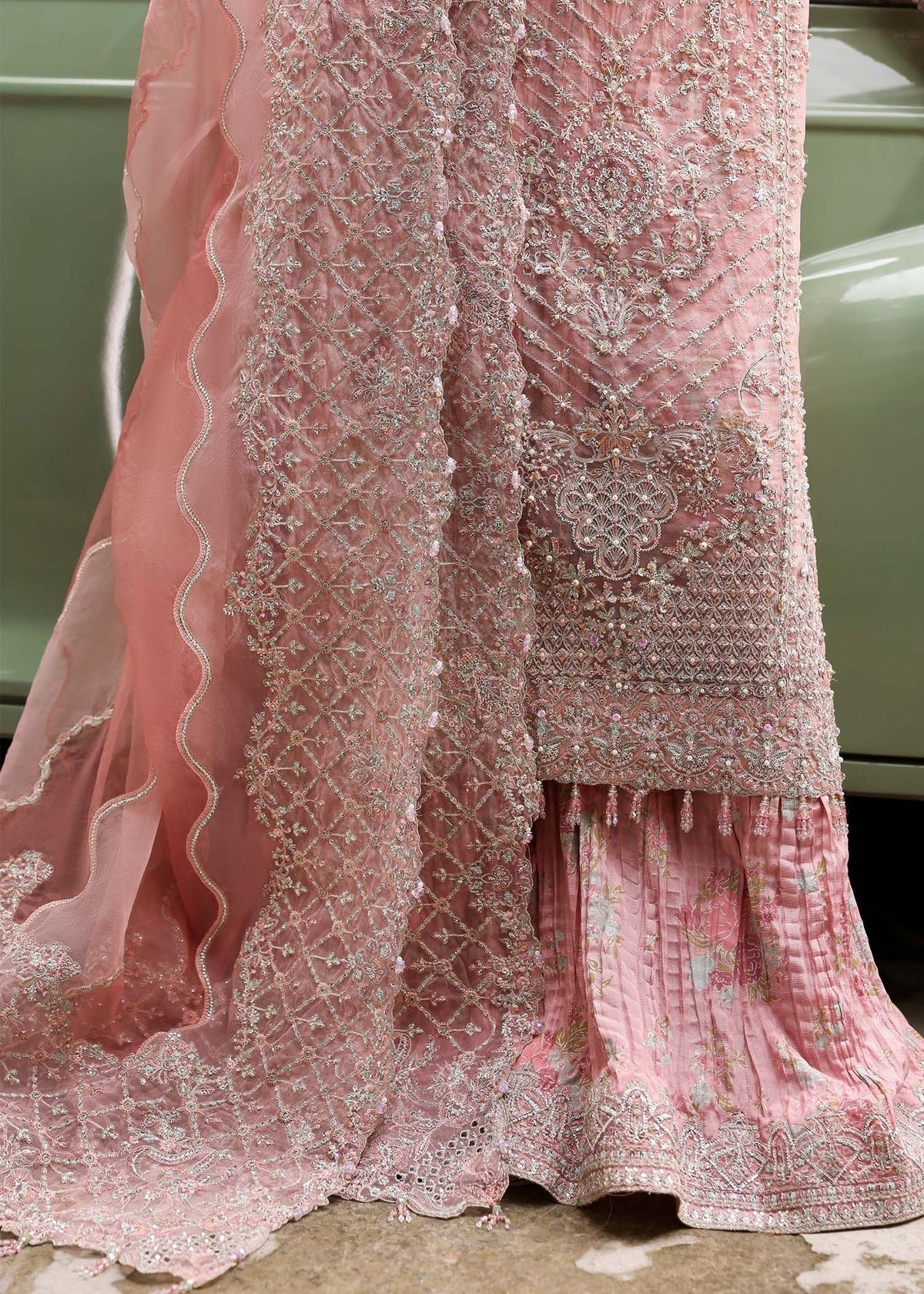 Ethereal blush rose suit with hand-embellished organza panels, ornate borders, and embroidered dupatta. A timeless choice for festive elegance.
