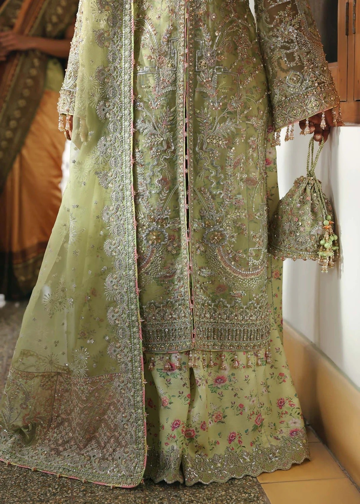 Vibrant parrot jade suit with hand-embellished organza panels, embroidered dupatta, and printed trouser—perfect for festive elegance.