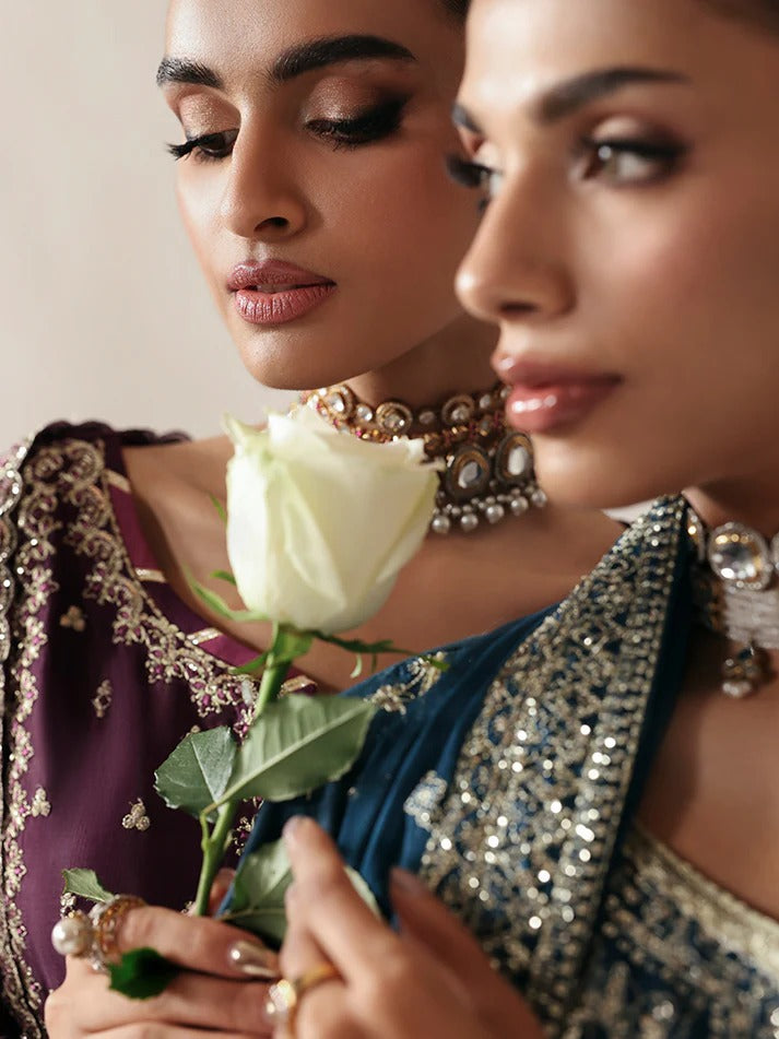 Luxurious raw silk outfit featuring embroidered and sequined panels, elegant chiffon dupatta with organza motifs, and matching dyed silk trouser.