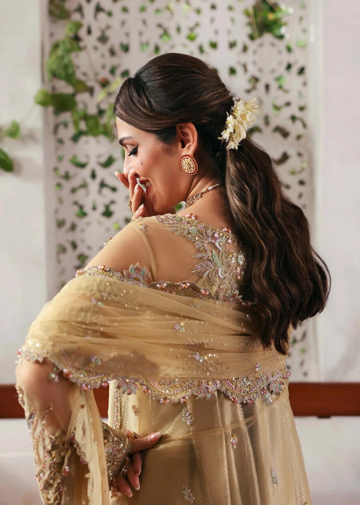 Elegant champagne beige suit with hand-embellished net panels, ornate borders, embroidered dupatta, and trouser for timeless festive sophistication.