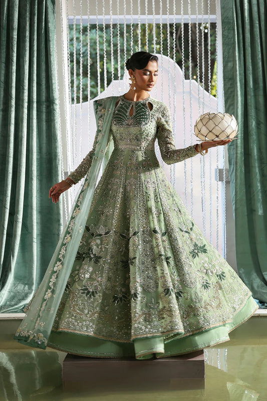 Elegant mint green silk suit featuring embroidered organza panels, velvet neck patch, net dupatta, and silk trousers. 