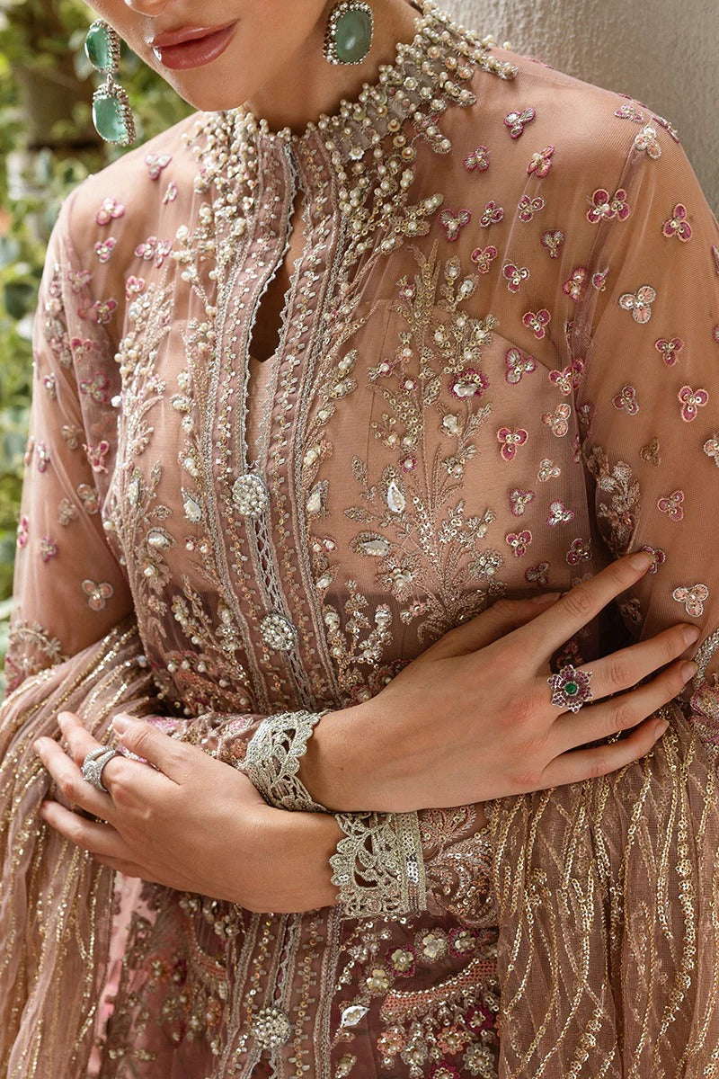 Elegant coral pink lehenga with embroidered net shirt, sequined dupatta, hand embellishments, and handmade tassels for a luxurious festive look.