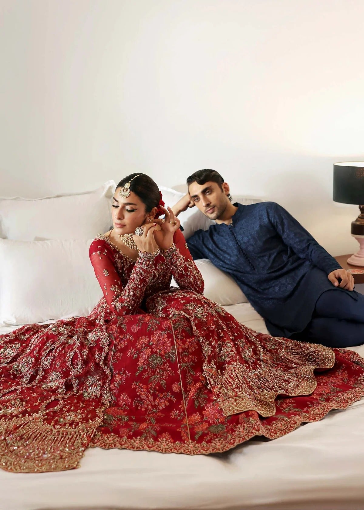 Regal crimson lehenga with hand-embellished panels, ornate borders, embroidered dupatta, and net body—perfect for festive and wedding elegance.