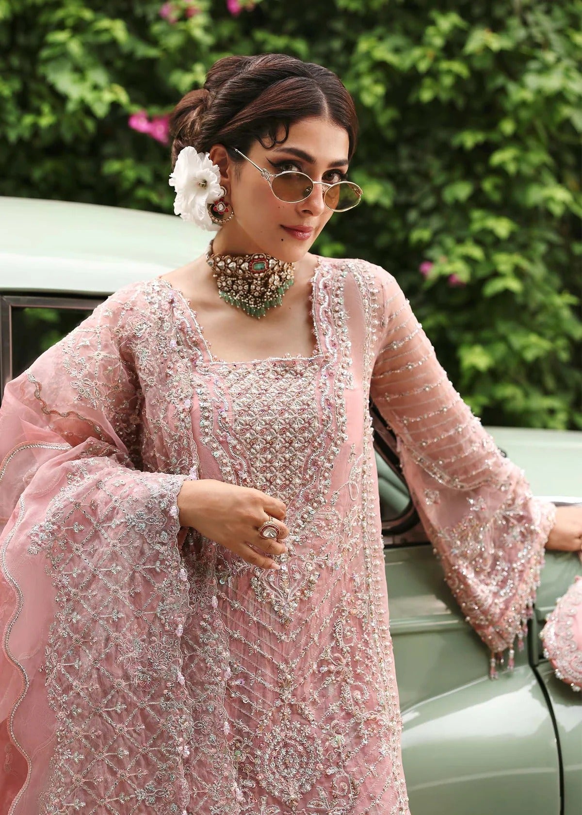 Ethereal blush rose suit with hand-embellished organza panels, ornate borders, and embroidered dupatta. A timeless choice for festive elegance.