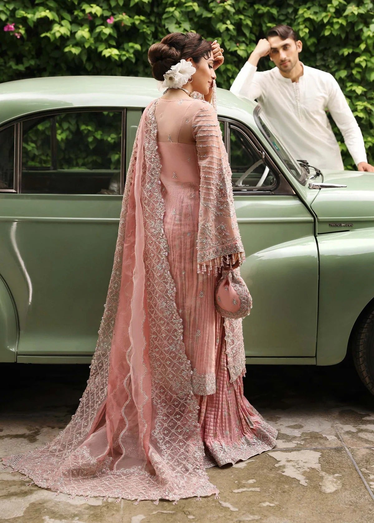 Ethereal blush rose suit with hand-embellished organza panels, ornate borders, and embroidered dupatta. A timeless choice for festive elegance.