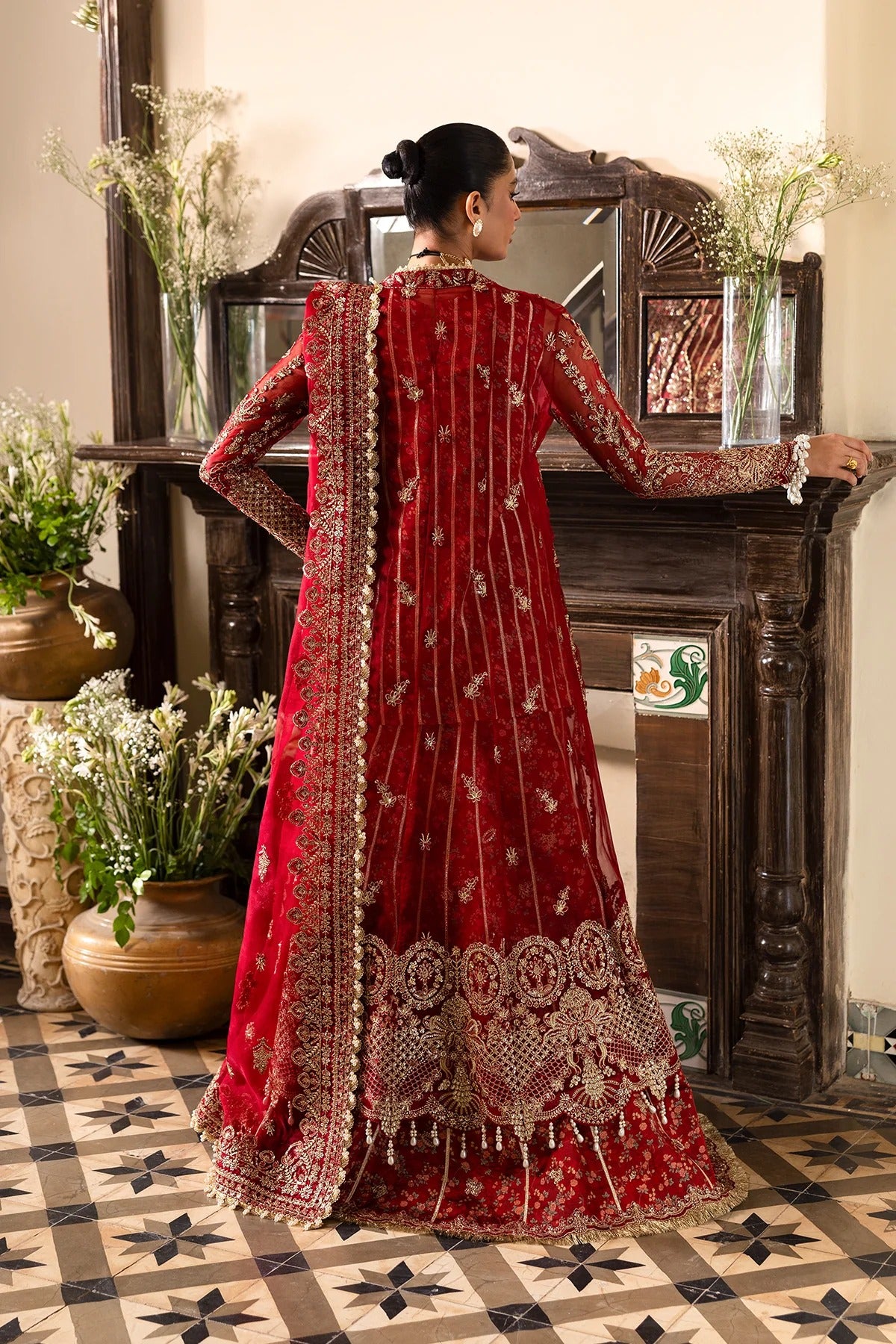 Striking red organza outfit with rich embroidery, dupatta, printed inner shirt, and embroidered trousers. A bold choice for weddings or festive events.