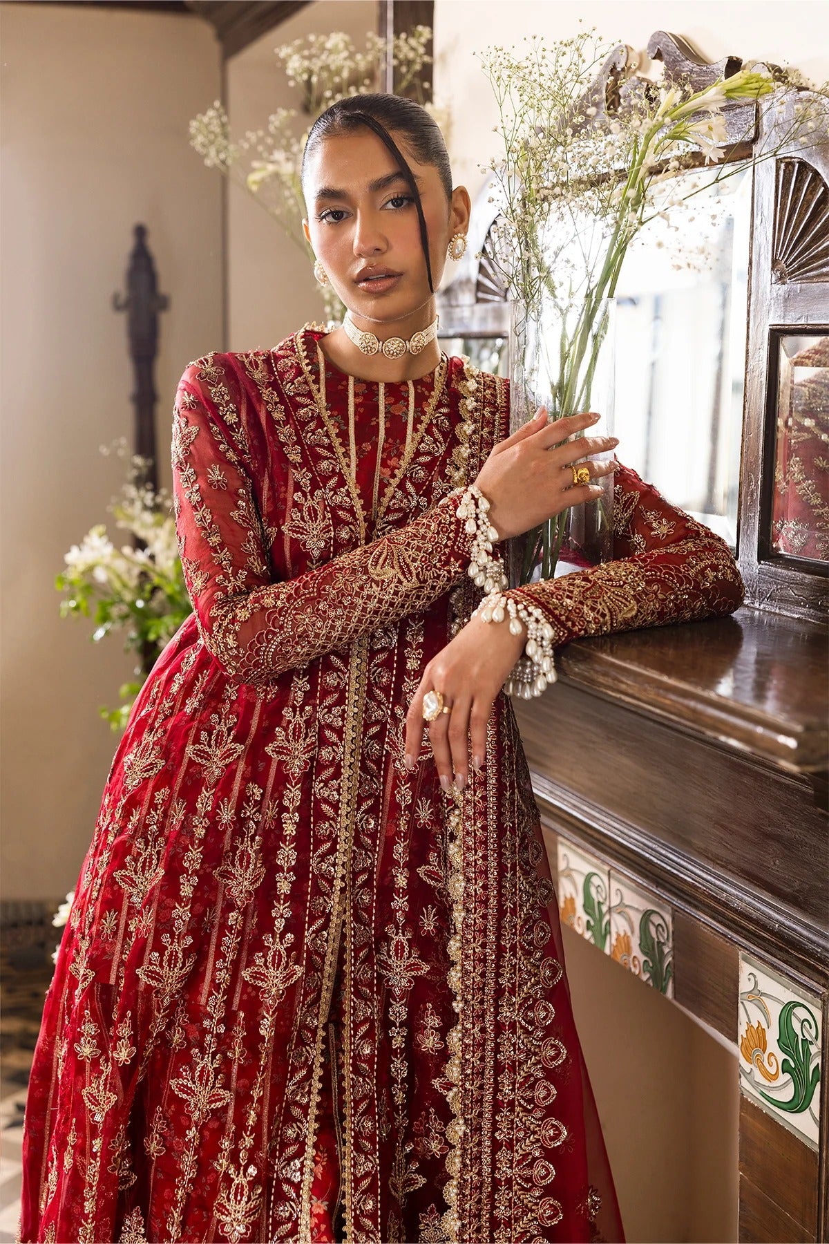 Striking red organza outfit with rich embroidery, dupatta, printed inner shirt, and embroidered trousers. A bold choice for weddings or festive events.