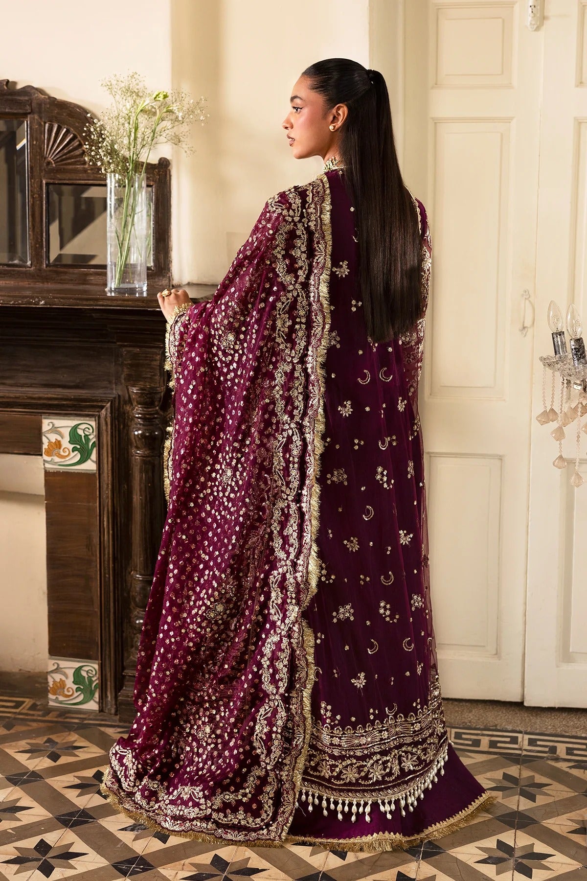 Luxurious plum ensemble featuring raw silk and net embroidery, detailed dupatta borders, and dyed trousers. A perfect pick for festive and formal wear.