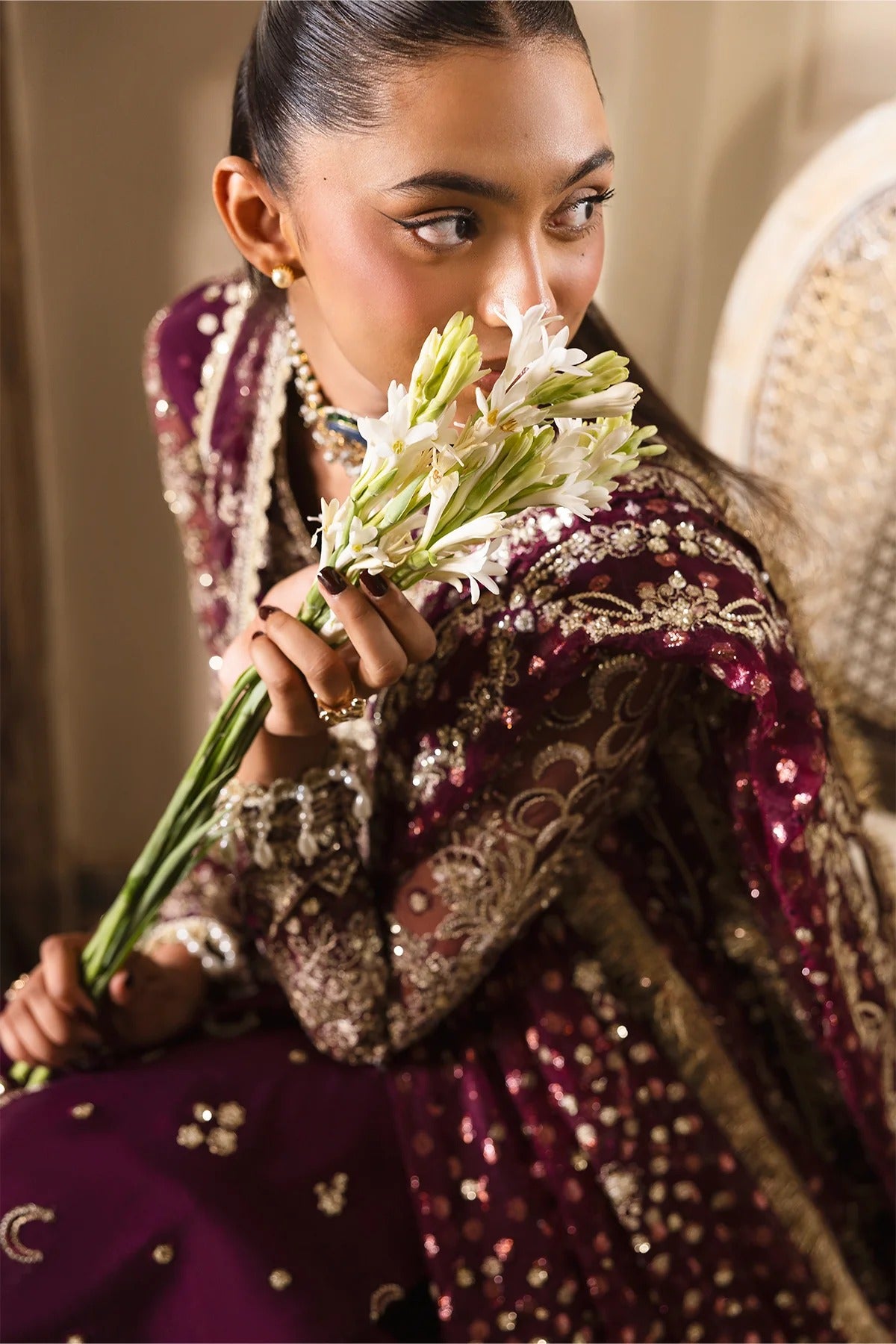 Luxurious plum ensemble featuring raw silk and net embroidery, detailed dupatta borders, and dyed trousers. A perfect pick for festive and formal wear.