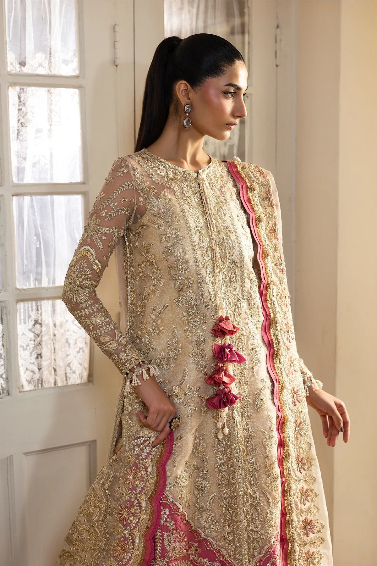 Graceful off-white organza dress with fine embroidery, dupatta, coral & pink borders, and jamavaar trousers. Perfect for elegant festive occasions.