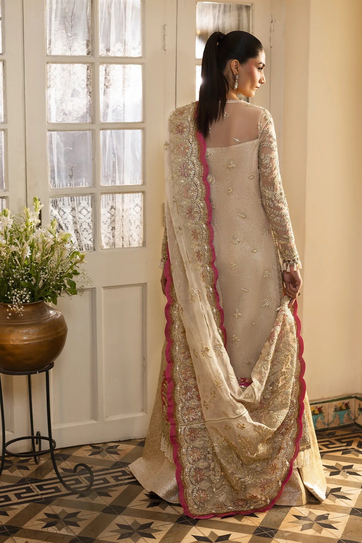 Graceful off-white organza dress with fine embroidery, dupatta, coral & pink borders, and jamavaar trousers. Perfect for elegant festive occasions.