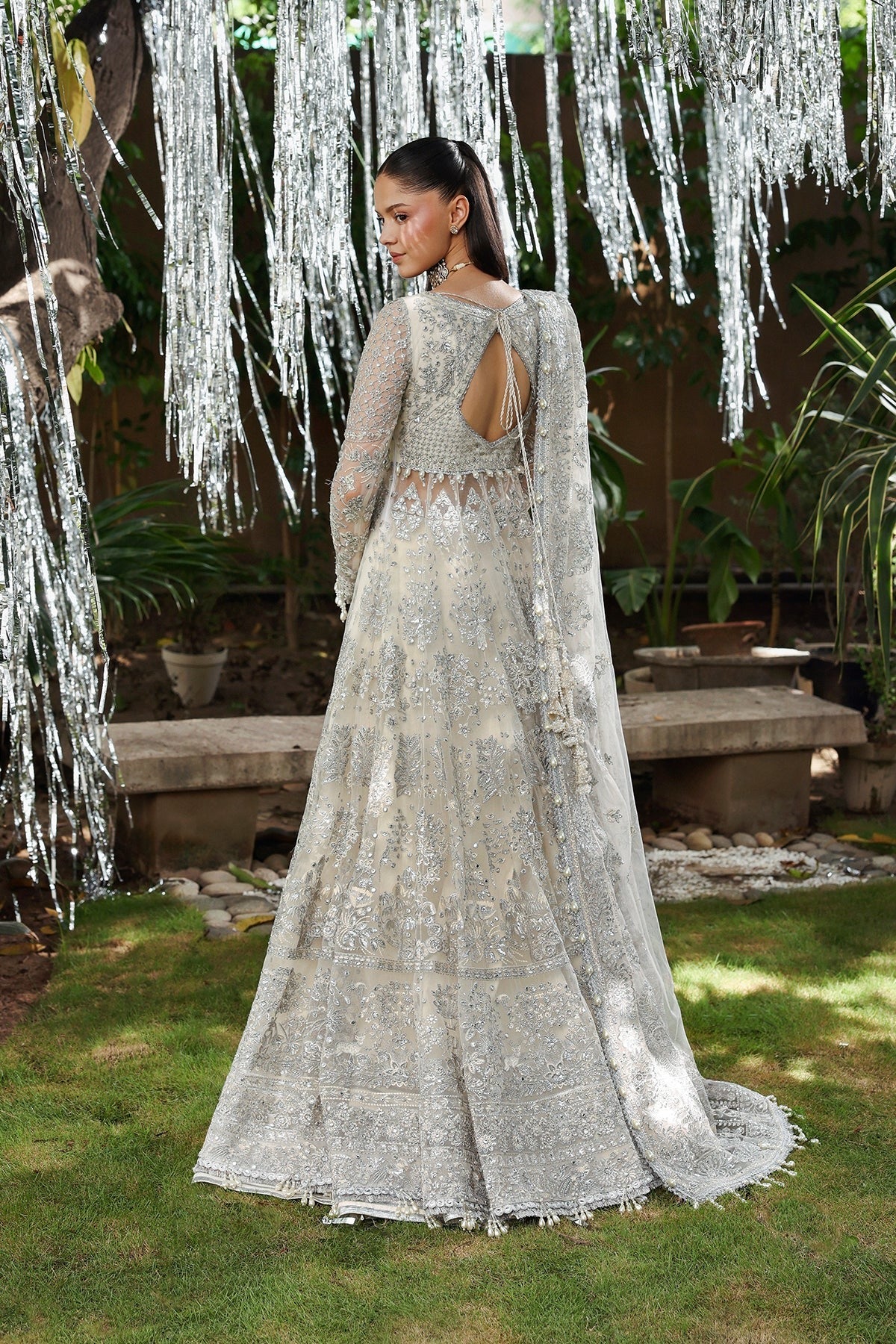 Elegant white net embroidered dress with detailed panels, organza dupatta borders, and raw silk trousers. Ideal for weddings and formal occasions.