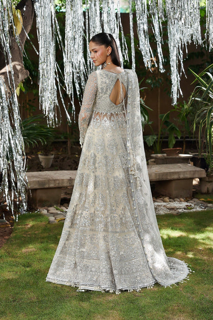 Elegant white net embroidered dress with detailed panels, organza dupatta borders, and raw silk trousers. Ideal for weddings and formal occasions.