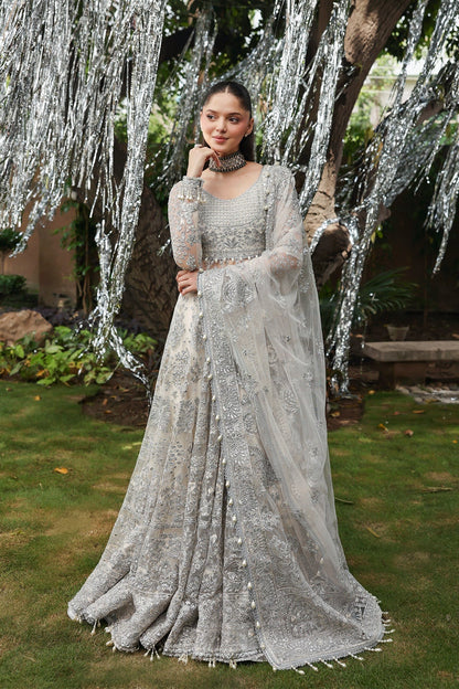 Elegant white net embroidered dress with detailed panels, organza dupatta borders, and raw silk trousers. Ideal for weddings and formal occasions.