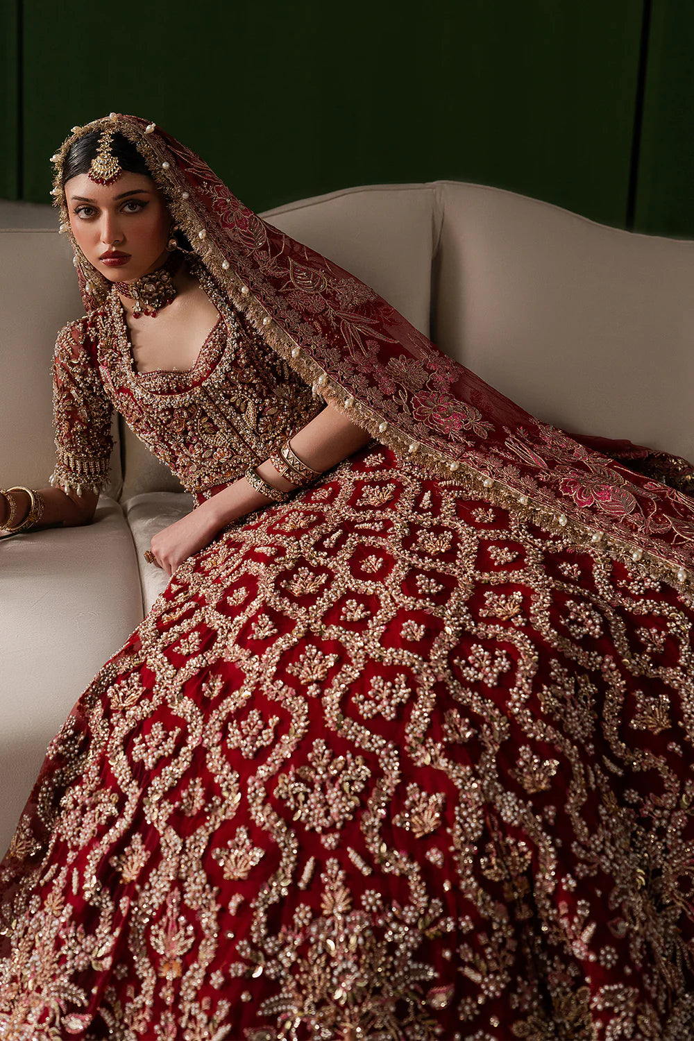 Opulent magenta bridal lehenga with intricate hand embellishment and antique embroidery. Paired with a richly detailed sheer dupatta.