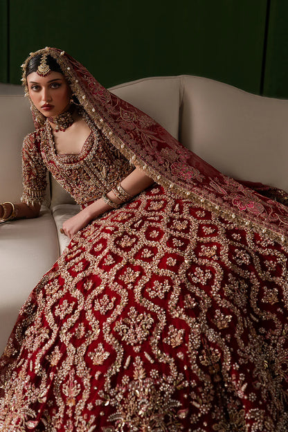 Opulent magenta bridal lehenga with intricate hand embellishment and antique embroidery. Paired with a richly detailed sheer dupatta.