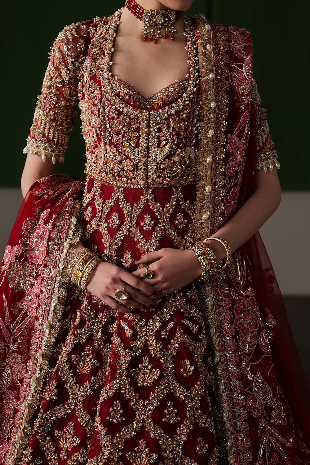 Opulent magenta bridal lehenga with intricate hand embellishment and antique embroidery. Paired with a richly detailed sheer dupatta.