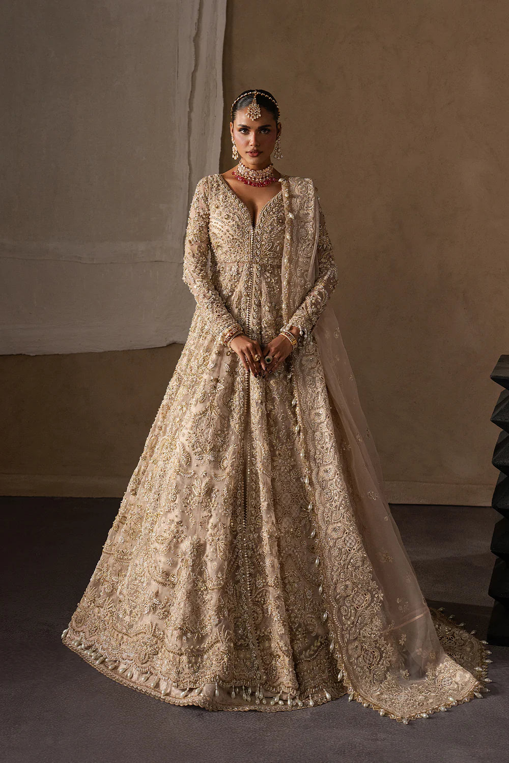 Majestic champagne bridal lehenga with hand embellishment and antique gold embroidery. Features ornate motifs, flowing skirt and elegant dupatta.