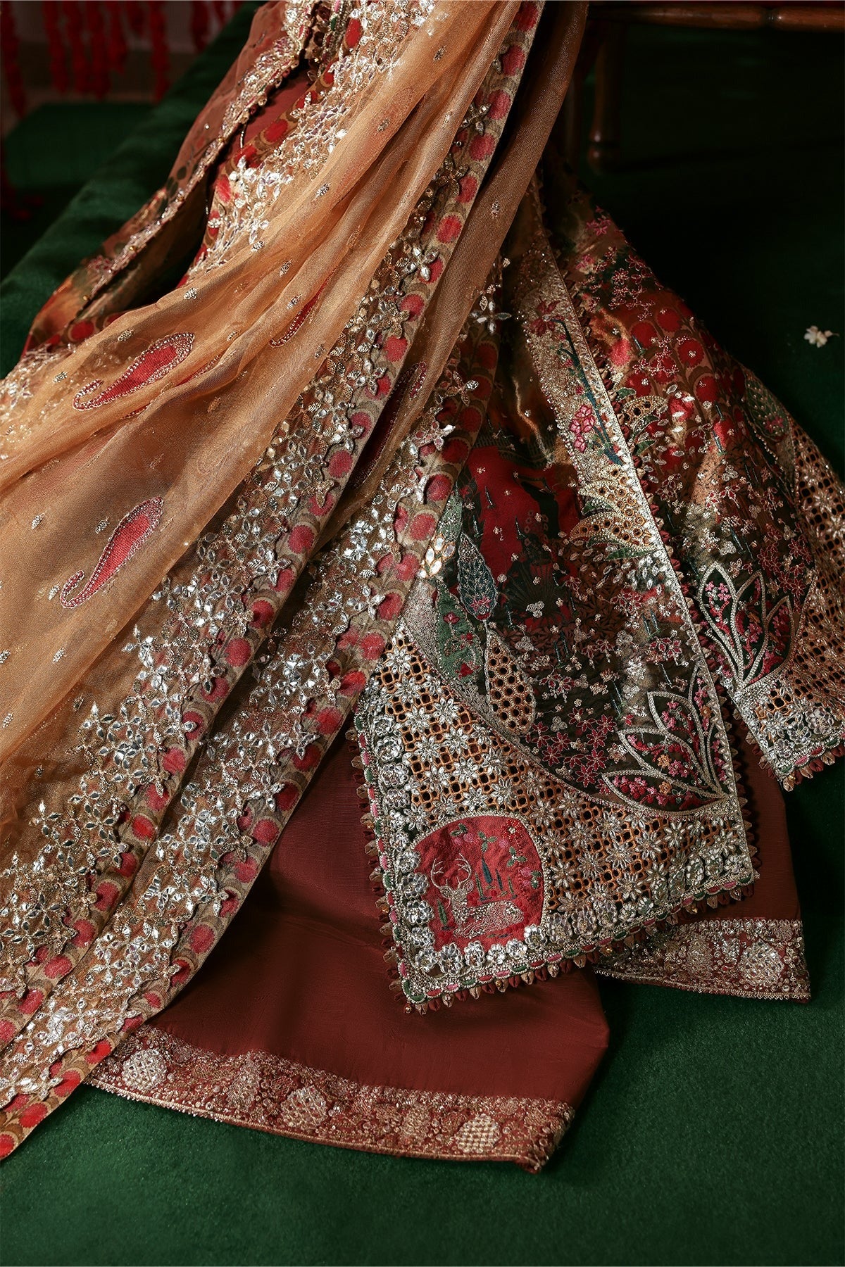 Elegant peach tissue dress with digital prints, zari embroidery, kundan net dupatta, and rust raw silk trouser. A perfect blend of tradition and style.