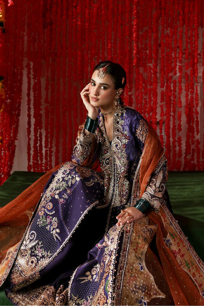 Regal purple raw silk dress with intricate embroidery, rust organza dupatta, and printed tissue zari patches. Ideal for festive and formal occasions.