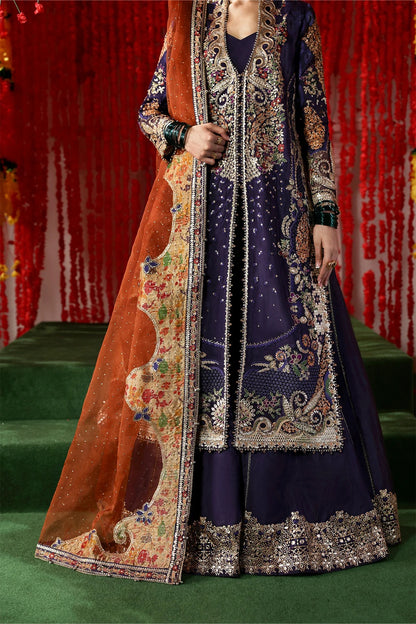 Regal purple raw silk dress with intricate embroidery, rust organza dupatta, and printed tissue zari patches. Ideal for festive and formal occasions.